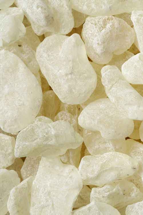 A close-up pile of translucent, mastic stones filling the frame.